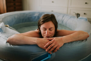 a woman looking relaxed leaning on a birth pool
