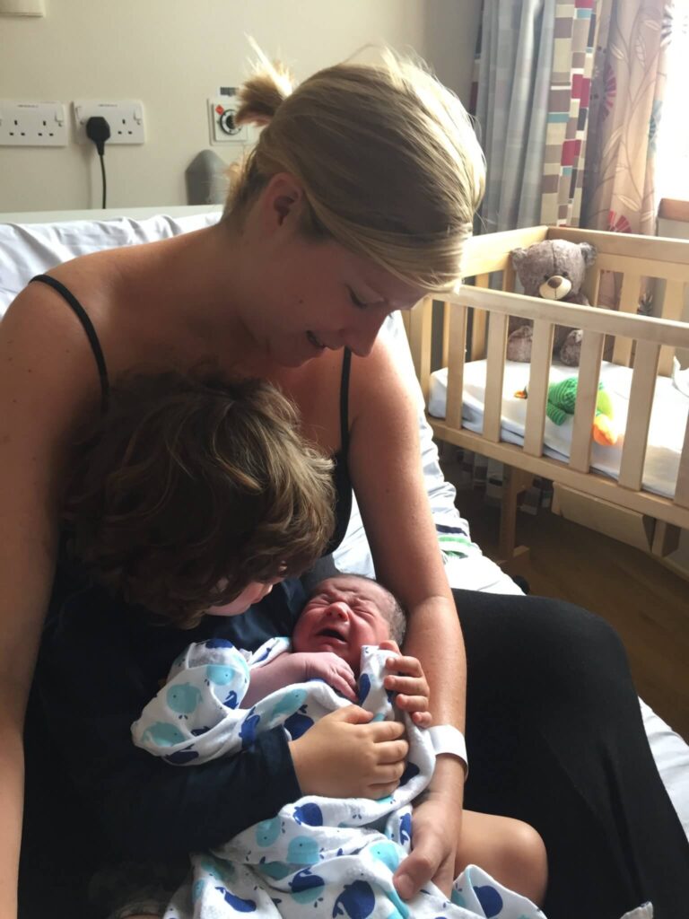 new mum and toddler holding newborn baby brother at whitehorse birth centre great western hospital